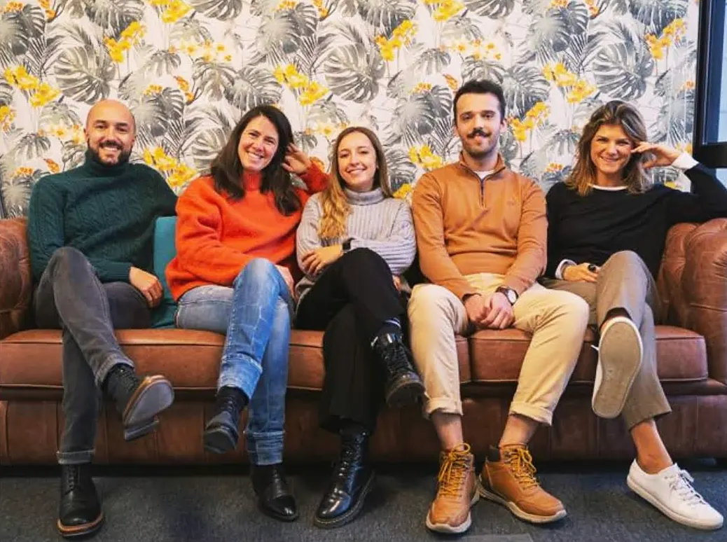 Ângelo Valente with colleagues at Doutor Finanças, five people on a leather sofa